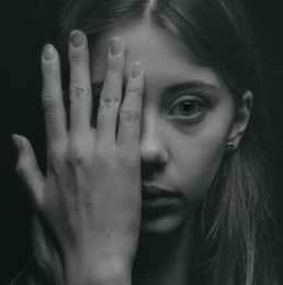 grayscale photo of woman covering her face by her hand